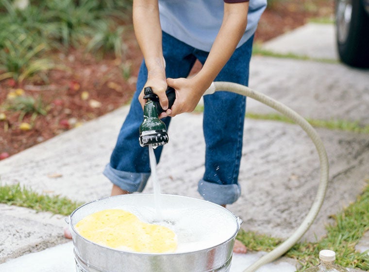 "boy holding water hose"