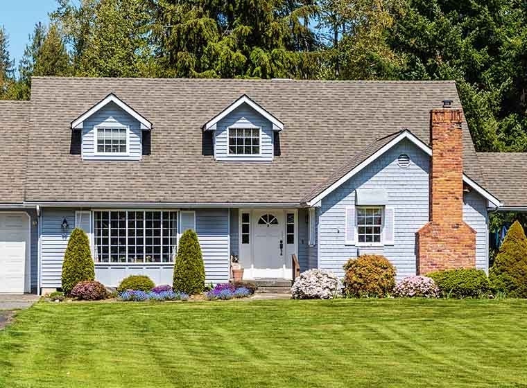 "Neat blue suburban home, freshly cut lawn"