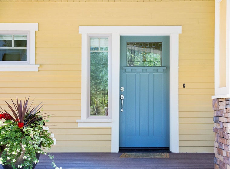 yellow exterior home with brick accents