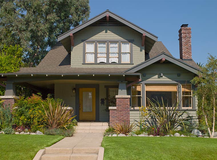 Green exterior home with brick accents