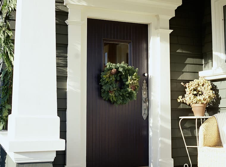 Black front door with holiday wreath