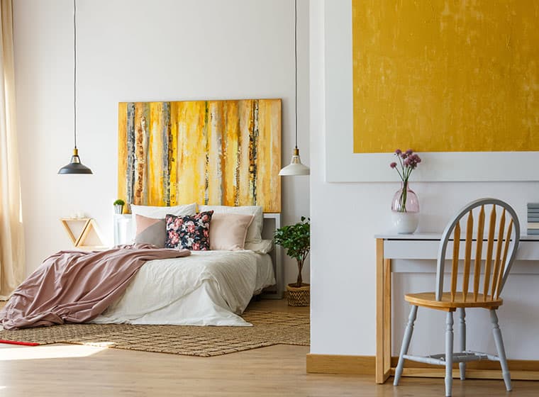 white guest bedroom with hanging lights and small desk