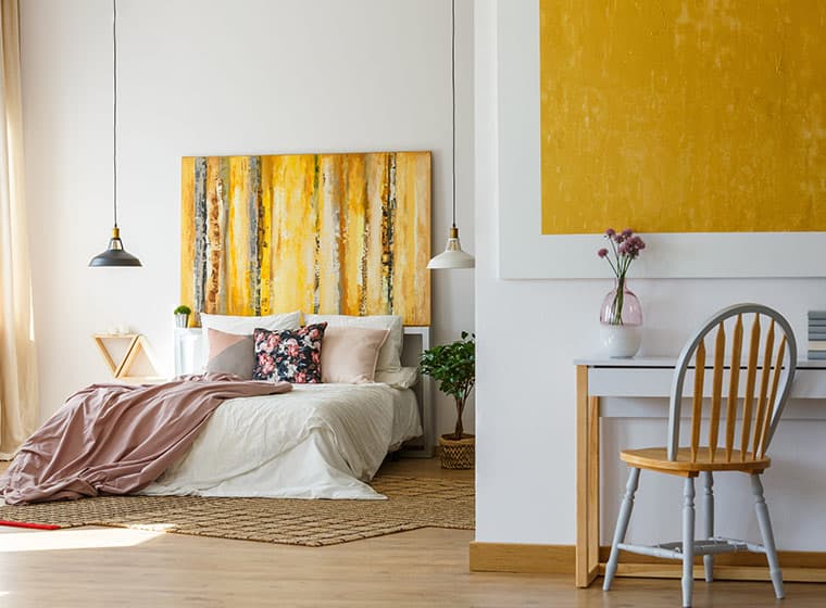 white guest bedroom with hanging lights and small desk 